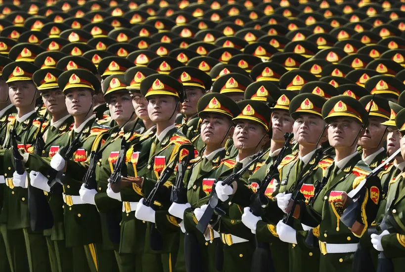 Soldados chineses em formação impecável, marchando com precisão e disciplina, destacando a organização militar.