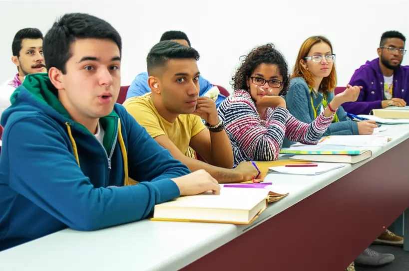 Grupo de estudantes engajados em um debate animado sobre a história do Brasil e a Proclamação da República, com livros e mapas na mesa.