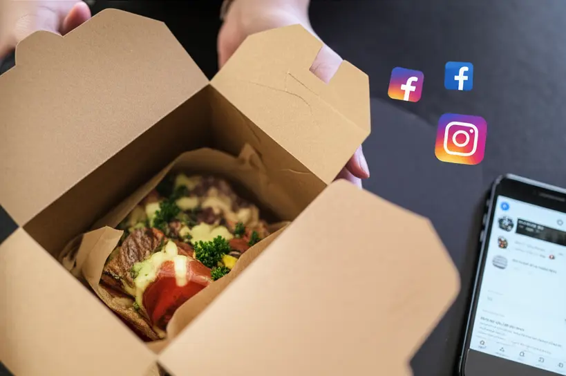 Mãos abrindo uma embalagem Kraft de delivery com comida apetitosa e um smartphone ao lado, indicando compartilhamento social